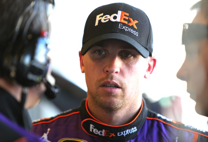 INDIANAPOLIS, IN - JULY 24: Denny Hamlin, driver of the #11 FedEx Express Toyota, stands in the garage area during practice for the NASCAR Sprint Cup Series Crown Royal Presents the Jeff Kyle 400 at the Brickyard at Indianapolis Motorspeedway on July 24, 2015 in Indianapolis, Indiana. (Photo by Jerry Markland/Getty Images)